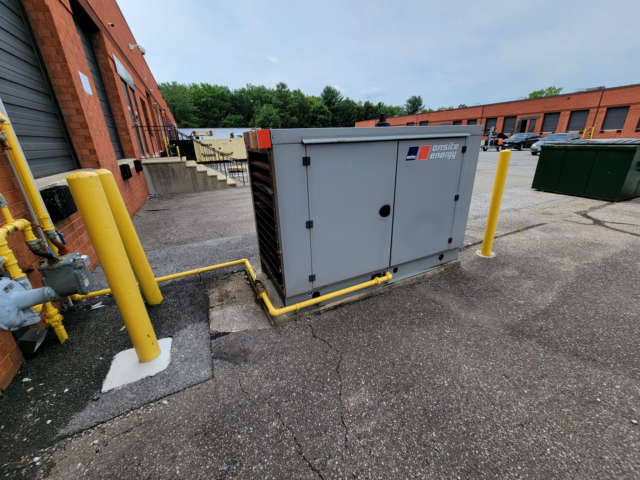 Standby generator with yellow fuel gas piping connected along the building exterior
