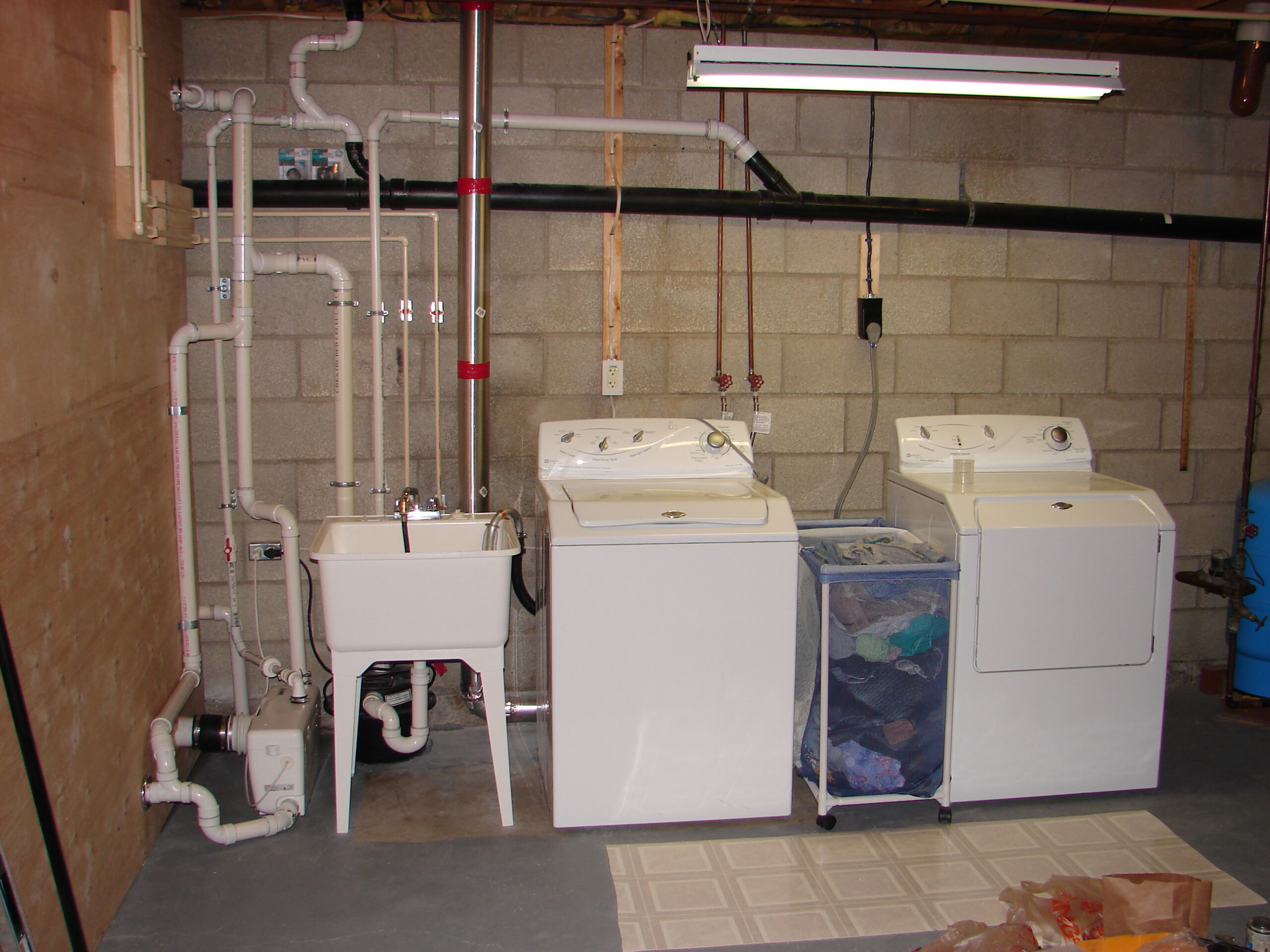 Residential utility area plumbing with laundry and service piping